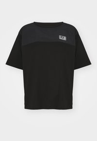 Svart t-shirt med kortärmad design, med en kontrasterande mörk panel upptill och en broderad logotyp på bröstet.