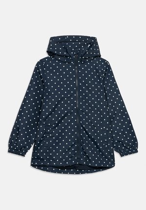 Veste de pluie pour enfants bleu marine à pois blancs, avec une fermeture éclair à l'avant, des poignets élastiques, des poches et une capuche.