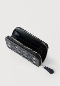 Συμπαγές μαύρο πορτοφόλι με φερμουάρ περιμετρικά, με υφή και διακοσμητικό μοτίβο στο μπροστινό μέρος, πολλαπλές θήκες για κάρτες και μαύρο δερμάτινο τμήμα για το τράβηγμα του φερμουάρ ανοιχτό σε λευκή επιφάνεια.