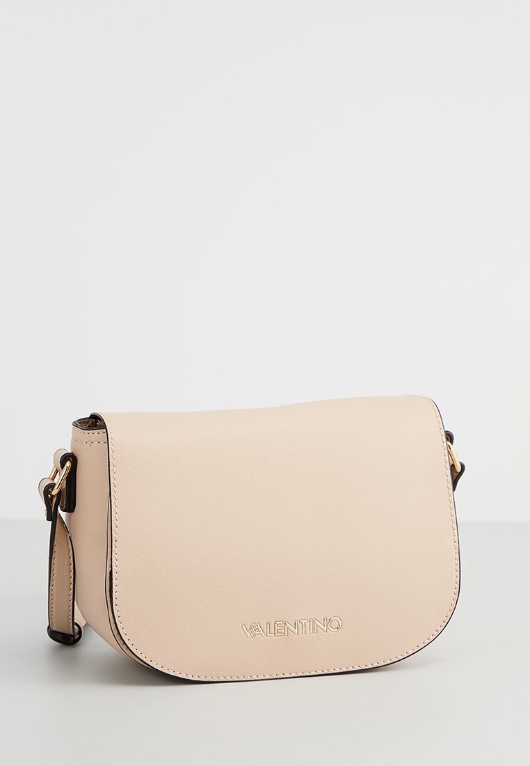 Sac en cuir beige à bandoulière avec rabat arrondi, quincaillerie dorée et logo embossé à l'avant. Bandoulière ajustable avec couture contrastante.