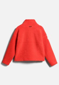 Veste polaire rouge vif à manches longues et col montant, vue de dos sur un fond gris neutre.