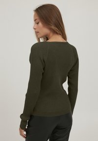 Pulover ribbed de culoare verde măslinie, cu guler rotund și mâneci lungi, având o siluetă ajustată și un material texturat.