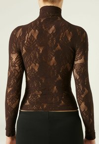 Top de cuello alto de encaje marrón con mangas largas, que presenta intrincados patrones florales y un diseño ajustado. Tejido texturizado, semi-translúcido.