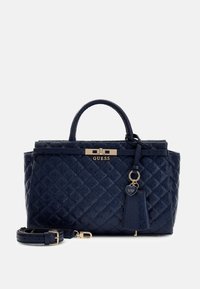 Granatowa torebka pikowana z złotym okuciem, z uchwytem górnym, odpinanym paskiem na ramię oraz zawieszką w kształcie serca.