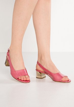 Lodičky na podpatku v lesklé růžové kůži s odkrytým prstem, s metalickým blokovým podpatkem a kulatým knoflíkovým detailem na pásku.