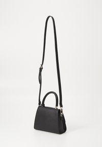 Sac à main en cuir noir avec une forme structurée, doté d'une poignée supérieure et d'une longue bandoulière réglable. Design minimaliste sans motifs visibles.
