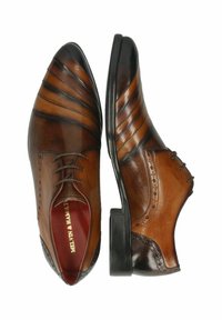 Des chaussures de ville en cuir marron présentent un bout pointu, un motif ondulé subtil sur les côtés et un décor brogue complexe au niveau du talon.