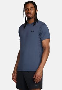 Camiseta atlética de manga corta en tejido azul oscuro, con un pequeño logo negro en el pecho, de textura suave y diseño ajustado.