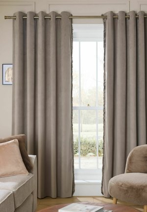 Taupe Samtvorhänge teilweise geöffnet, die ein weißes Fenster mit einem Garten draußen zeigen, flankiert von einem beigen Sofa und einem braunen Sessel.