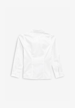 Baltas ilgas palaidinukas su klasikiniais atlapais, lygaus paviršiaus ir mygtukinėmis rankovėmis. Turi pritaikytą siluetą ir švarias linijas.