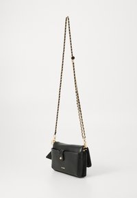 Black faux leather crossbody bag with a gold chain strap, fold-over flap, and a small side pocket. Features gold-tone hardware and logo.