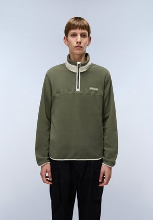 Olivgrüner Fleece-Pullover mit hohem Kragen, Viertelreißverschluss vorne und weißen Akzenten entlang des Kragens und Saums. Lockere Passform und flache Nähte.