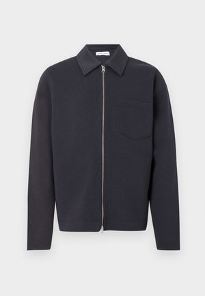 Veste zippée bleu marine foncé avec col pointu, poche poitrine unique et manches longues ; fabriquée en tissu texturé à finition lisse.