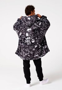 Juodas gobtuvu oversize džemperis su baltomis grafikos detalėmis, įskaitant tekstą ir simbolius, pagamintas iš minkštos medžiagos ir pasižymintis laisvu kirpimu.