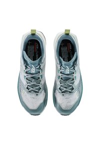Lichtblauwe en grijze sport schoenen met een gestructureerde bovenkant, veters en groene accenten, van bovenaf bekeken tegen een witte achtergrond.