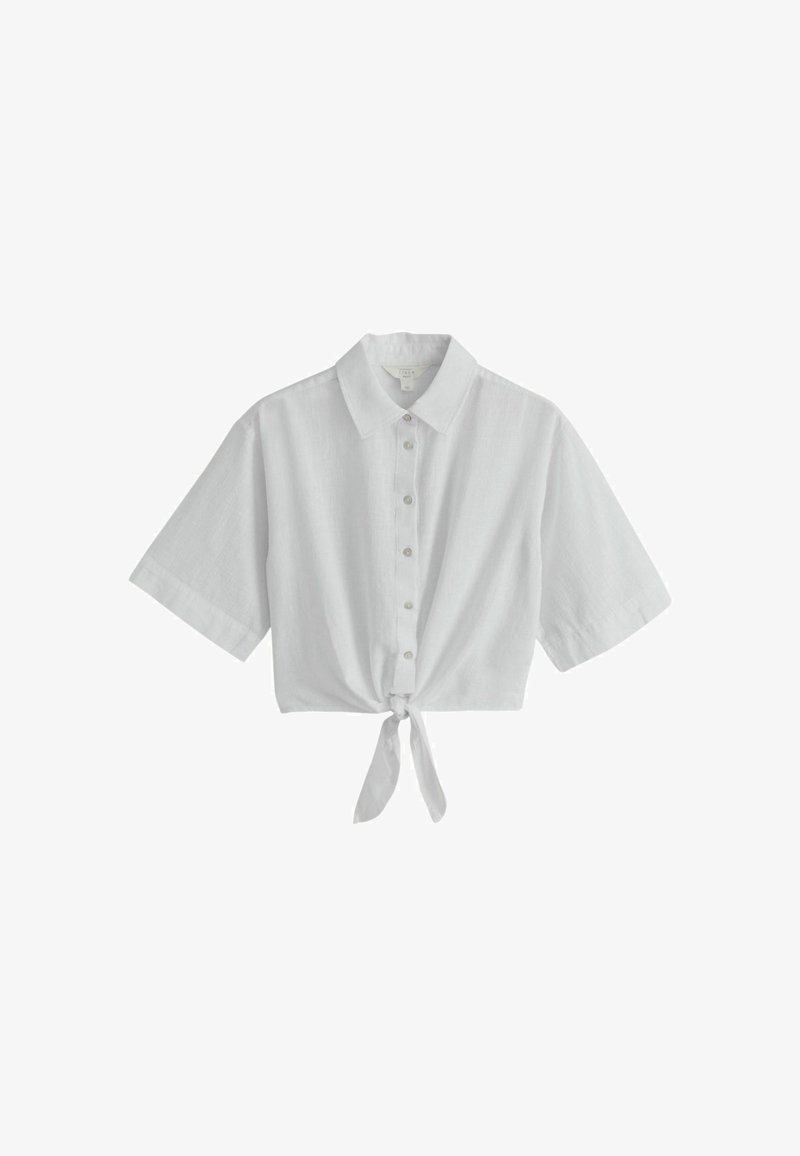 Chemise blanche à manches courtes avec col et nœud à l'avant, en tissu léger.