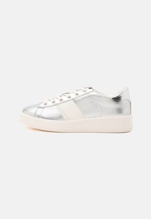 Sneaker con piattaforma bassa, tomaia argentata lucida, lacci bianchi e suola e striscia laterale color crema, mostrata di profilo su sfondo bianco.