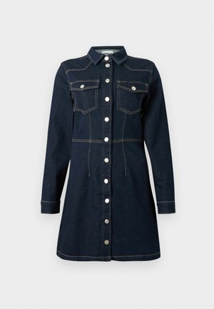 Vestido de ganga azul-escuro com mangas longas, fecho frontal com botões, dois bolsos de chapa no peito e costuras em contraste.