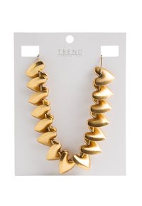 Złota, błyszcząca naszyjnik składający się z zakrzywionych, sercowych koralików połączonych razem. Wyeksponowany na białej karcie z otworem do zawieszenia.