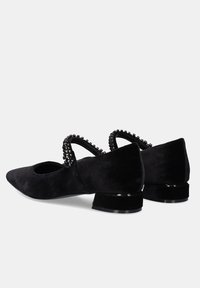 Zapatos bajos de ante negros con puntera afilada y una tira decorativa de cuentas. Textura suave y un acabado brillante sutil en el tacón.