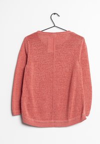 Sweter z dzianiny w miękkim koralowym kolorze, o prostym designie, z długimi rękawami i zaokrąglonym dołem. Wisi na czarnym haku do wyświetlania.