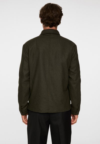 Olivgrön ullblandad jacka med en strukturerad krage, knappar vid ärmslut och rak passform. Har en ren baksida med minimala sömmar.