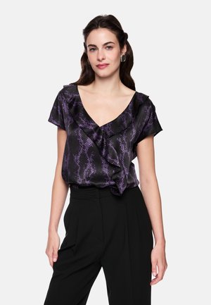 Black blouse with purple snake print, ruffled neckline, and short sleeves, paired with high-waisted black trousers.