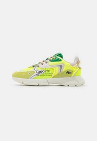 Sneaker Lacoste s živým žlutým síťovinovým svrškem, zelenými akcenty a šedými semišovými detaily. Disponuje polstrovanou podrážkou a kontrastními tkaničkami.