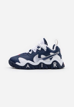 Mørkeblå og hvid Nike sneaker med chunky sål med bogstaverne "A I R", løkke til at trække i og hvide snørebånd.
