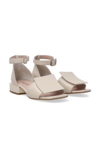 Beige Sandalen mit offener Zehenpartie, Riemen um den Knöchel, flache Blockabsätze und großen überlappenden Klappendetails an der Vorderseite. Aus glattem Leder.