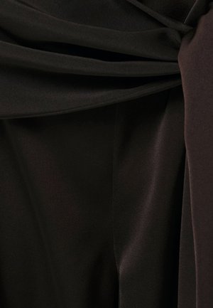 Nærbillede af blødt, mørkebrunt stof med glatte folder og let glans.