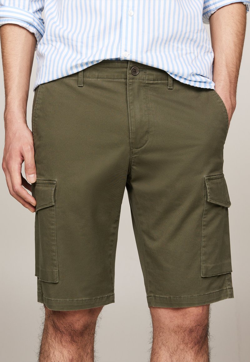 Shorts cargo verts olive en tissu léger, dotés de deux poches latérales, d'un ourlet cousu et d'une coupe décontractée.