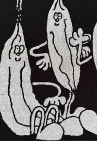 Schwarzer Teppich mit weißen, cartoonähnlichen Charakteren, die Bananen ähneln und Gesichts- sowie Körperausdrücke, Arme und Beine haben, vor einem strukturierten Hintergrund.