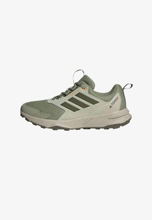 Green mesh and synthetic outdoor shoe with gray accents, textured detailing, and a rugged sole. Features three dark stripes and a pull tab.