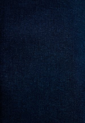 Tessuto di denim blu scuro con una superficie testurizzata, caratterizzato da sottili variazioni di tonalità e motivo di tessitura. Nessun hardware o dettagli visibili.