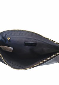 Borsa in pelle nera con una texture liscia, tasca interna con zip, dettagli in zip dorata e un design semplice.