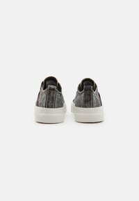 Gray denim slip-on shoes with a white rubber sole, featuring a textured finish and gold stitching accents on the heel.