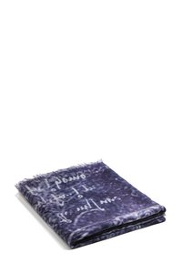 Sciarpa viola con una texture morbida, caratterizzata da testo bianco in stile calligrafico e bordi sfilacciati, piegata ordinatamente.