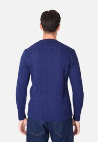Maglione lavorato a maglia blu navy con motivo a diamante testurizzato, collo rotondo e polsini e orlo a coste. Vista che mostra il retro e le maniche.