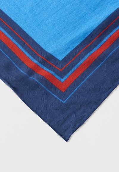 Γωνία με μπλε ύφασμα με στρωτές ρίγες σχήματος ζιγκ-ζαγκ σε ναυτικό μπλε, κόκκινο και ανοιχτό μπλε σε λευκό φόντο.