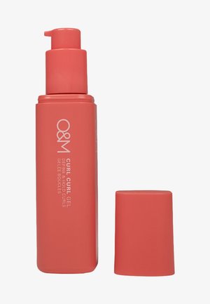 Koraalkleurige plastic fles van O&M Curl Curl Gel met een pompdispenser, zachte textuur en een bijpassend deksel. Etiket gedrukt in het wit.