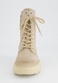Beige Leder-Stiefelette mit Schnürung auf der Vorderseite, silbernen Ösen und seitlichem Reißverschluss. Verfügt über eine klobige cremefarbene Sohle für zusätzlichen Halt und Höhe.