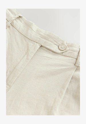 Heleda beez linane kangas, millel on sile tekstuur, ühe ümmarguse nupuga klapiga ja pehmelt volditud vöökoht.