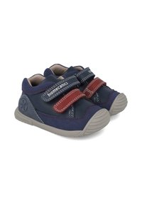 Chaussures pour enfants bleu marine avec des sangles Velcro réglables rouges, semelles en caoutchouc et coutures blanches contrastantes. Matériau en daim doux.
