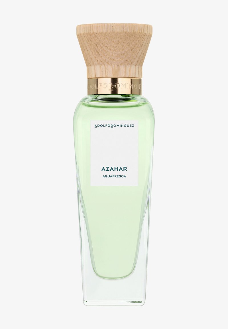 Grande bouteille de parfum en verre transparent avec un liquide vert clair, bouchon en bois et étiquette portant la mention « Adolfo Dominguez Azahar Aguafresca ».