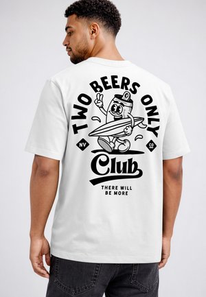 Man wearing white shirt with black graphic of smiling beer can holding surfboard and peace sign, text "Two Beers Only Club, There Will Be More."