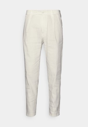 Ljusbeige skräddarsydda byxor i mjukt tyg, med knappstängning, veck framtill och avsmalnande ben. Slät struktur.