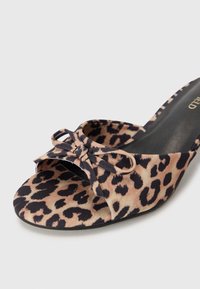 Leopard print slide sandal with a soft fabric upper, open toe, and bow detail at the front. Black sole with minimal tread pattern.