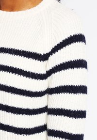 Maglione lavorato a maglia con collo rotondo, caratterizzato da righe orizzontali marine e bianche. Il tessuto ha un aspetto strutturato e a coste.