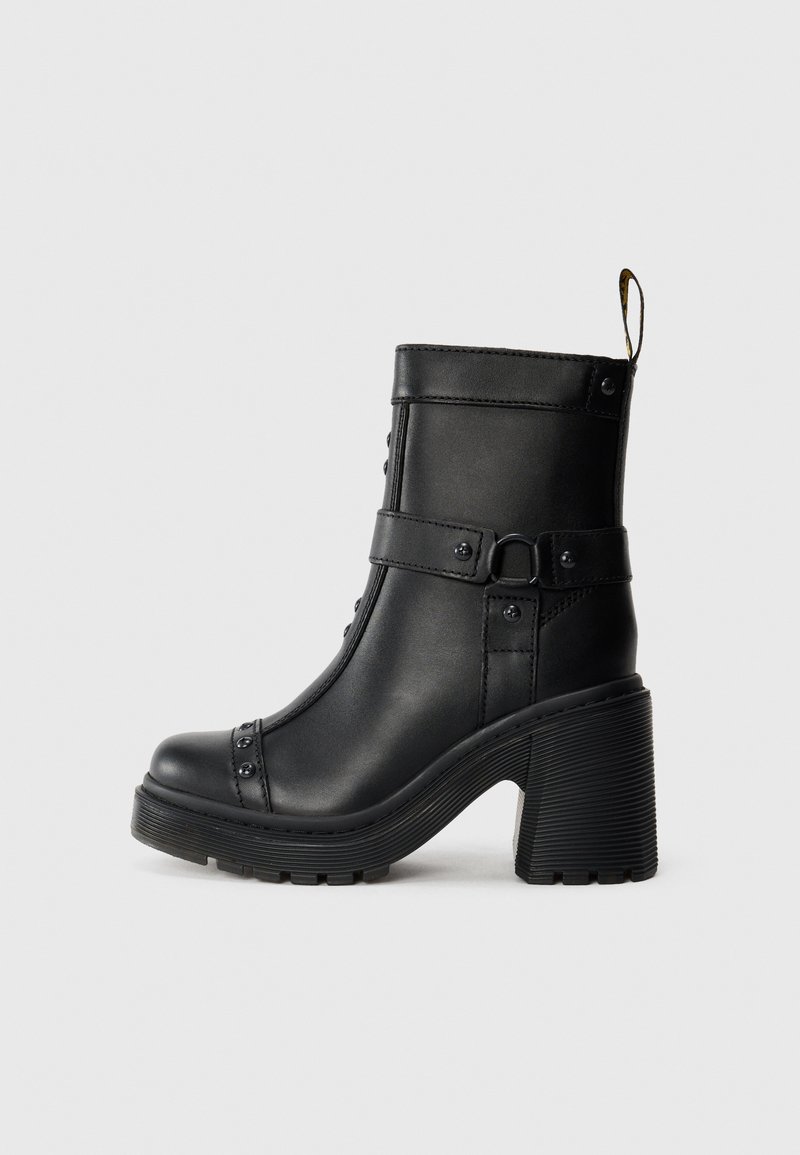 Stivali ankle in pelle nera con tacco alto e massiccio, dettaglio della fibbia laterale e borchie decorative lungo la cucitura anteriore. Suola in gomma texturizzata.